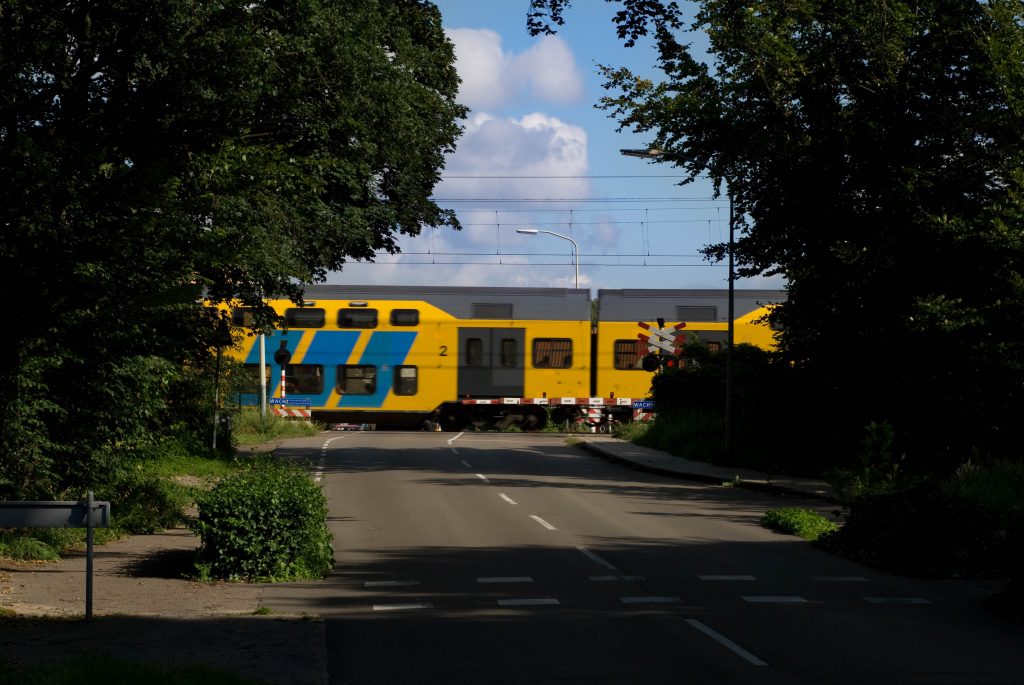 Een NS-trein passeert een spoorwegovergang, foto: Sweco
