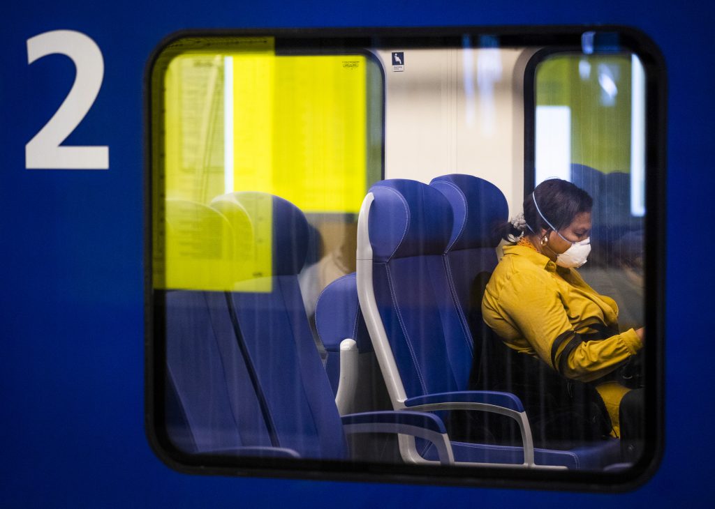 Een reiziger met een mondkapje in een NS-trein, foto: ANP