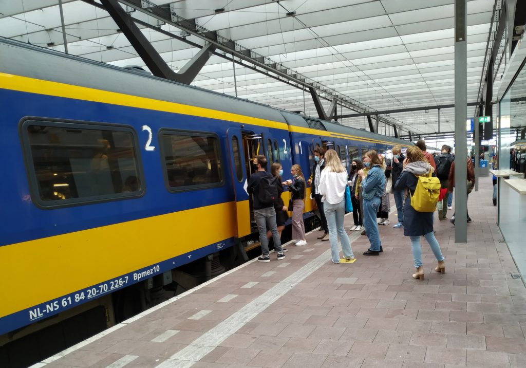 Reizigers met mondkapjes op het perron van Rotterdam Centraal